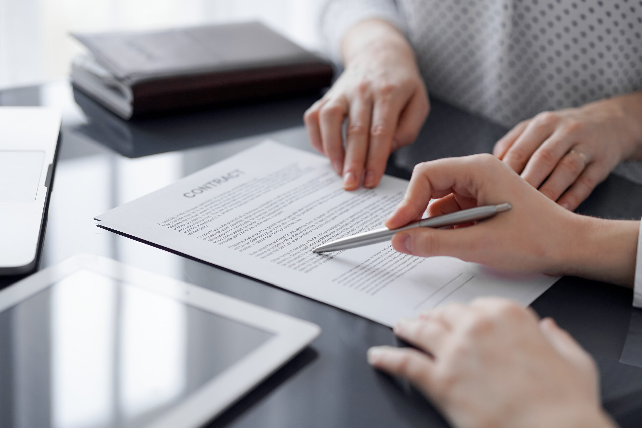 Business people discussing contract signing deal while sitting at the glass table in office, closeup. Partners or lawyers working together at meeting. Teamwork, partnership, success concept gente-de-negocios-discutiendo-la-firma-de-contratos-mientras-estan-sentados-en-la-mesa-de-vidrio-en-la-oficina-de-cerca-socios-o-abogados-trabajando-juntos